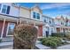 Exterior view of charming townhomes with brick accents, landscaping, and inviting entrances at 7963 Shadow Oak Dr, North Charleston, SC 29406