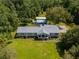 Aerial shot of a well-maintained home with a metal roof, lush lawn, and mature trees at 806 Appii Rd, Moncks Corner, SC 29461
