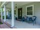Inviting front porch with rocking chairs, decorative pillows, and elegant columns creating a charming entryway at 806 Appii Rd, Moncks Corner, SC 29461