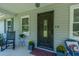 Classic front porch featuring an ornate front door, rocking chair, and decorative plants for a cozy welcome at 806 Appii Rd, Moncks Corner, SC 29461