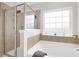 This elegant bathroom has a soaking tub, tiled walls and a glass enclosed shower at 9785 Black Willow Ln, Ladson, SC 29456