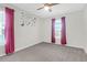 This bedroom with purple curtains has a neutral carpet and fan at 9785 Black Willow Ln, Ladson, SC 29456