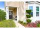 Inviting front entry with well-manicured landscaping, bench, and side lite windows at 9785 Black Willow Ln, Ladson, SC 29456