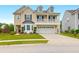 Charming two-story home featuring a welcoming front porch and attached garage, complemented by a well-manicured lawn at 9785 Black Willow Ln, Ladson, SC 29456