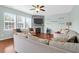Bright living room with fireplace, ceiling fan, hardwood floors, and large windows at 9785 Black Willow Ln, Ladson, SC 29456