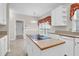 Kitchen island features a cooktop and white cabinets with tiled floors and lighting at 100 Cheshire Dr, Goose Creek, SC 29445