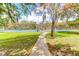Outdoor tennis courts with shade structures surrounded by lush trees and landscaping at 100 Cheshire Dr, Goose Creek, SC 29445