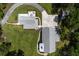 Birds eye view showcasing a white farmhouse-style home nestled amongst lush greenery, along with manicured lawn and driveway at 105 Bobcat Ln, Ravenel, SC 29470