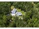 Aerial view of a well-maintained home with lush landscaping and an expansive driveway surrounded by forest at 105 Bobcat Ln, Ravenel, SC 29470