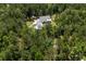 Aerial view showcases a charming home nestled among mature trees on a sprawling lot at 105 Bobcat Ln, Ravenel, SC 29470