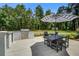 Outdoor kitchen with built-in grill and dining table, set against a backdrop of lush green trees at 105 Bobcat Ln, Ravenel, SC 29470