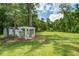 Grassy backyard featuring a pergola with lattice surround and a small shed behind it at 105 Bobcat Ln, Ravenel, SC 29470