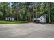 Spacious concrete area featuring two detached sheds, one of which is a sports court with a basketball hoop at 105 Bobcat Ln, Ravenel, SC 29470