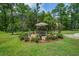 Backyard featuring outdoor seating beneath an umbrella and a stone patio surrounded by trees at 105 Bobcat Ln, Ravenel, SC 29470