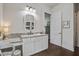 Vanity area in this bathroom with granite counters, decorative mirror, white cabinets, and wood floors at 105 Bobcat Ln, Ravenel, SC 29470