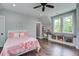 Charming bedroom featuring hardwood floors, soft gray walls, window bench, and stylish decor at 105 Bobcat Ln, Ravenel, SC 29470