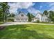 Spacious property featuring a lush green lawn, detached garage, and charming home with a welcoming facade at 105 Bobcat Ln, Ravenel, SC 29470