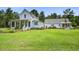 Beautiful two-story white farmhouse with a welcoming porch and a lush green lawn at 105 Bobcat Ln, Ravenel, SC 29470