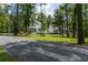 Exterior view of a charming farmhouse-style home with a wrap-around porch and mature trees at 105 Bobcat Ln, Ravenel, SC 29470