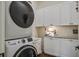 Laundry room featuring stacked washer and dryer, white cabinets, granite countertops, and wood floors at 105 Bobcat Ln, Ravenel, SC 29470