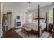 Spacious main bedroom with hardwood floors, four poster bed, chandelier, sitting area, and fireplace at 105 Bobcat Ln, Ravenel, SC 29470