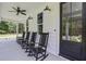 Inviting front porch with classic black rocking chairs and stylish lighting fixtures at 105 Bobcat Ln, Ravenel, SC 29470