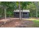 Shed with board and batten siding with a gray roof surrounded by trees and pine straw at 105 Bobcat Ln, Ravenel, SC 29470