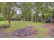 Large backyard featuring a fire pit, mature trees, and recreational equipment at 109 Fort St, Summerville, SC 29485