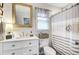 Well-lit bathroom featuring a white vanity, stylish mirror, and a neutral striped shower curtain at 109 Fort St, Summerville, SC 29485