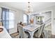 This lovely dining room features a rustic wood table with chandelier lighting and beautiful checkered curtains at 109 Fort St, Summerville, SC 29485