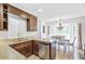 Well-lit kitchen with dark wood cabinets, granite countertops, and a view of the dining area at 109 Fort St, Summerville, SC 29485