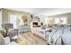 Cozy living room with white brick fireplace, decorative mantle, modern lighting, and wood flooring at 109 Fort St, Summerville, SC 29485
