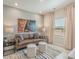 Comfortable living room with a leather sofa, plush ottomans, modern decor, and a large window at 109 Indigo Cove Blvd, Summerville, SC 29486