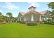 Charming clubhouse with red roof, white pillars, and lush landscaping provides a welcoming community space at 1103 Cates Ct, Summerville, SC 29483