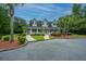 Charming, light gray clubhouse with black shutters surrounded by palm trees, manicured landscaping, and ample parking at 112 Lake Jogassee Dr, Summerville, SC 29485