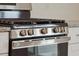 Close-up of a stainless steel gas range with four burners and matching knobs in a modern kitchen at 112 Moscato Ln, Summerville, SC 29485