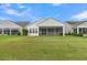 Home backyard featuring a screened-in porch and a sprawling green lawn at 117 Harbor Trace Ln, Summerville, SC 29486