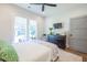 The bedroom features a sleek ceiling fan, two large windows and a decorative plant at 1174 Hitchfield Ln, Awendaw, SC 29429