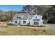 Beautifully landscaped two-story home with a classic white exterior, dark roof, and cozy front porch at 1174 Hitchfield Ln, Awendaw, SC 29429