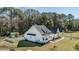 Beautiful modern farmhouse with white siding, black roof, and charming front porch, surrounded by mature trees at 1174 Hitchfield Ln, Awendaw, SC 29429