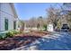 Backyard view of a white farmhouse-style home with a landscaped yard, storage shed and dining area at 1174 Hitchfield Ln, Awendaw, SC 29429