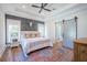 Beautiful bedroom with a decorative wall, stylish rug, and a sliding barn door leading to the ensuite bathroom at 1174 Hitchfield Ln, Awendaw, SC 29429