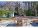 A wooden outdoor dining table is set on a backyard patio with a building in the background at 1174 Hitchfield Ln, Awendaw, SC 29429