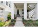Inviting ground-level porch with a cozy bench, plants and stylish stairs to upper level porch at 1182 Welcome Dr Dr, Mount Pleasant, SC 29464