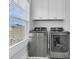 Bright laundry room with modern washer and dryer beneath storage cabinets at 1182 Welcome Dr Dr, Mount Pleasant, SC 29464