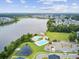 Aerial view showcases a lake, community pool, playground, and clubhouse surrounded by lush greenery at 121 Ancestry Ln, Moncks Corner, SC 29461