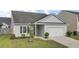 Beautiful single-story home featuring a well-kept lawn, small tree, and an attached two-car garage at 121 Ancestry Ln, Moncks Corner, SC 29461