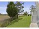 Expansive backyard featuring lush grass, mature trees, and scenic views of the marsh at 1216 Rivers Reach Dr, Charleston, SC 29492