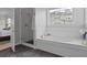 This bathroom features a soaking tub with subway tile surround, a tiled shower, and black marble flooring at 1216 Rivers Reach Dr, Charleston, SC 29492