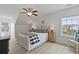 Bright bedroom boasts white walls, plank floors, and an iron bed frame with a checked blanket and ceiling fan at 1216 Rivers Reach Dr, Charleston, SC 29492